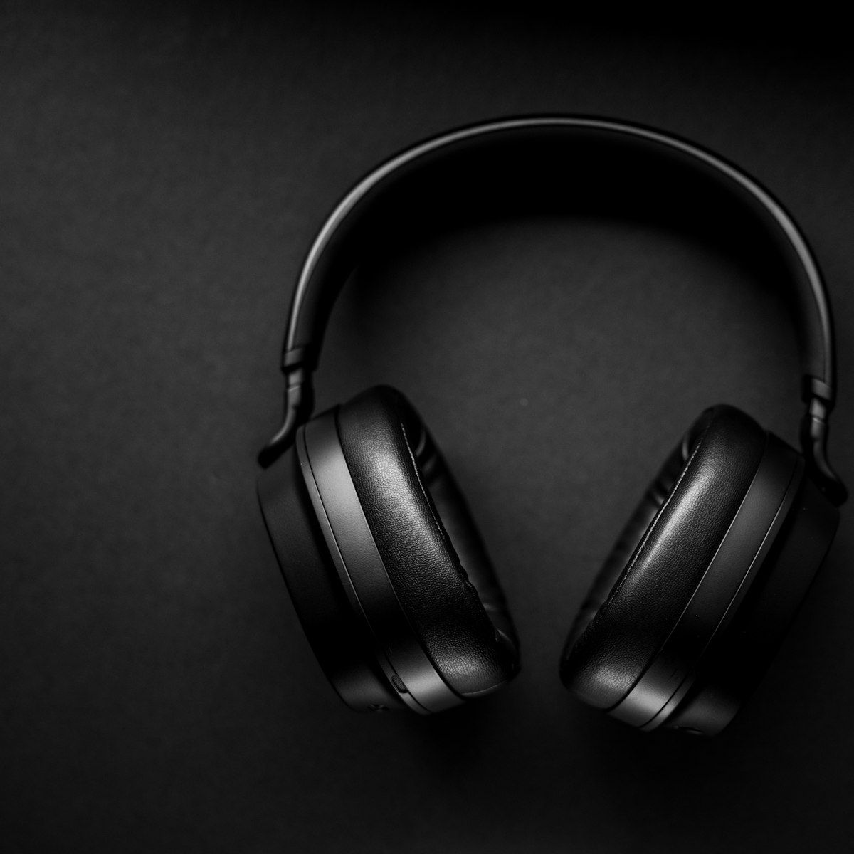 Black HELM headphones photographed top-down on dark, symmetric