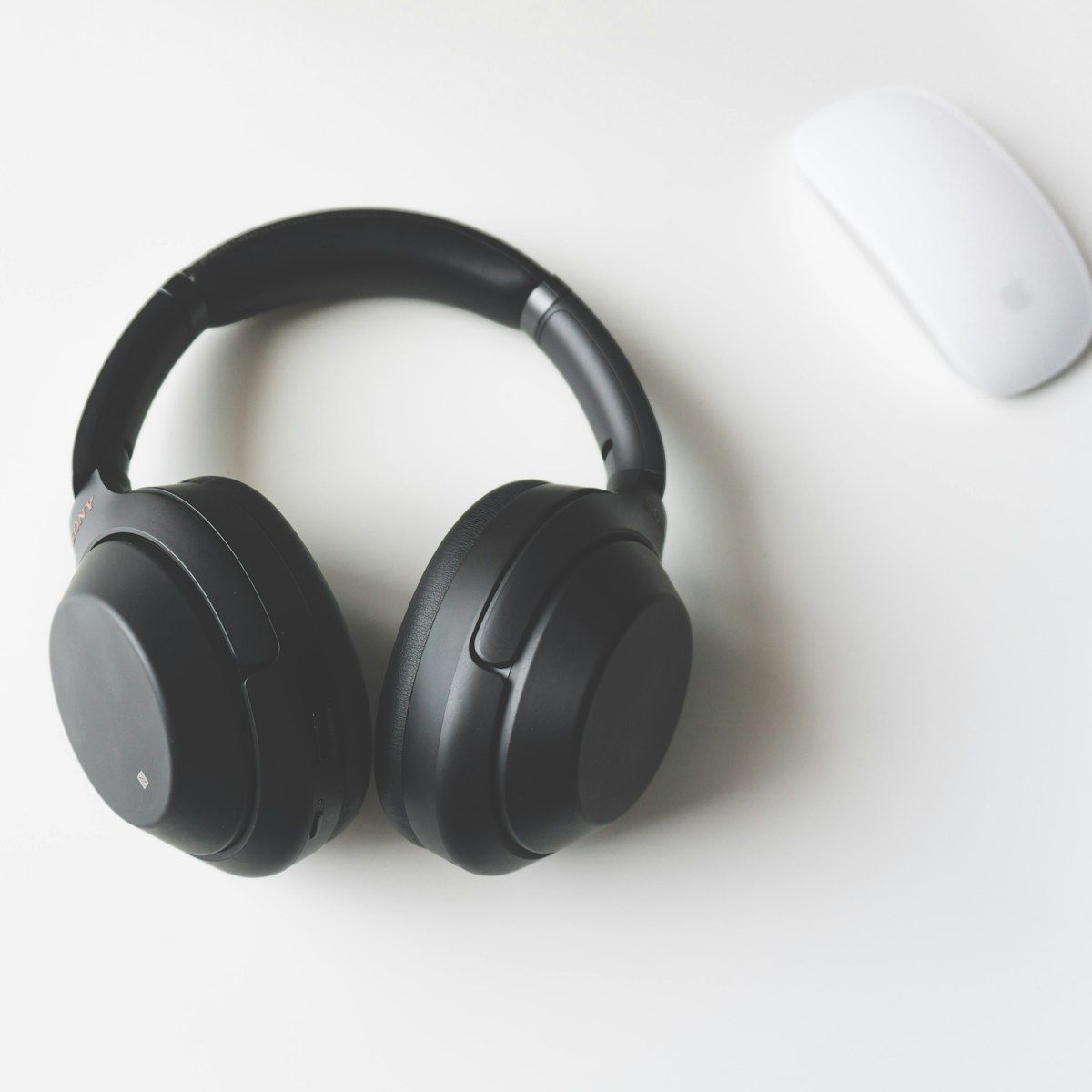 Black over-ear HELM headphones on a white desk