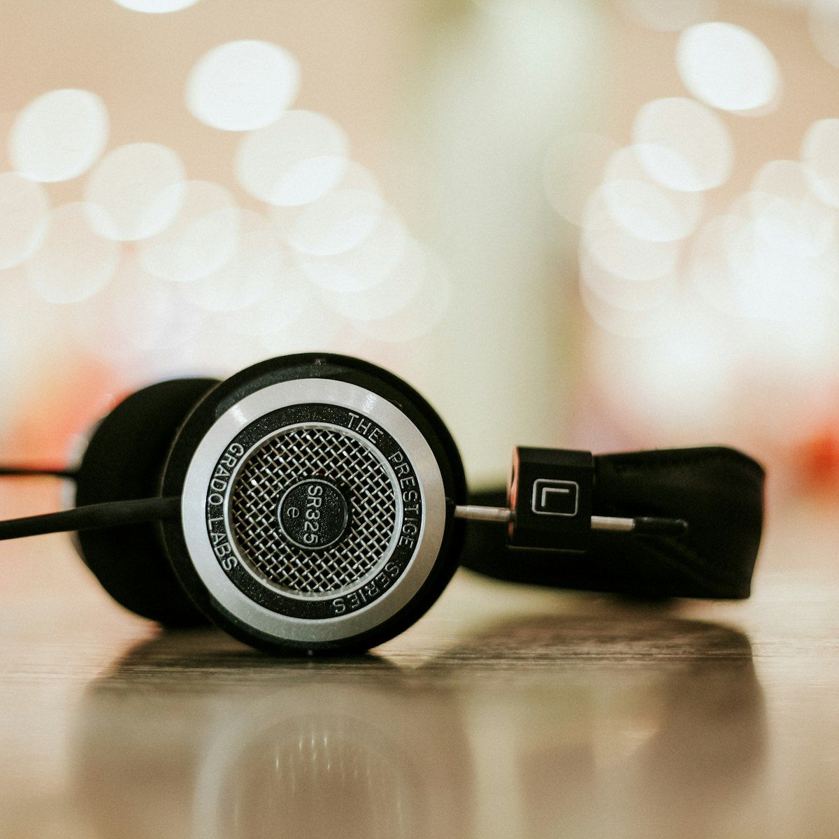 HELM open-back headphones resting on a surface with warm bokeh behind