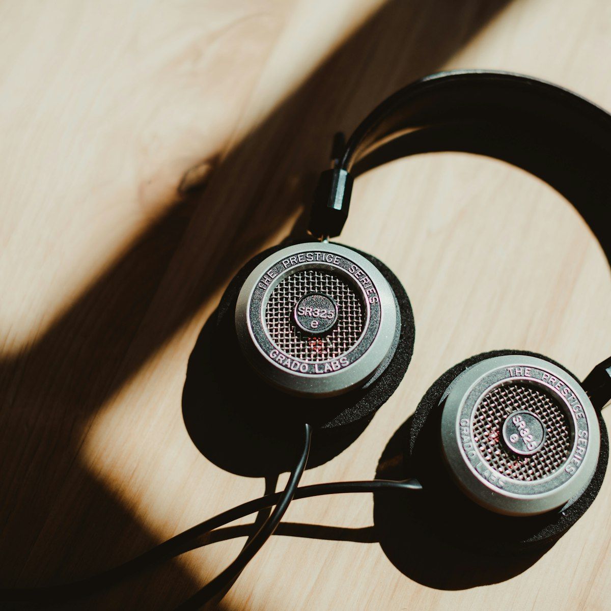 HELM headphones photographed top-down on a warm wood surface
