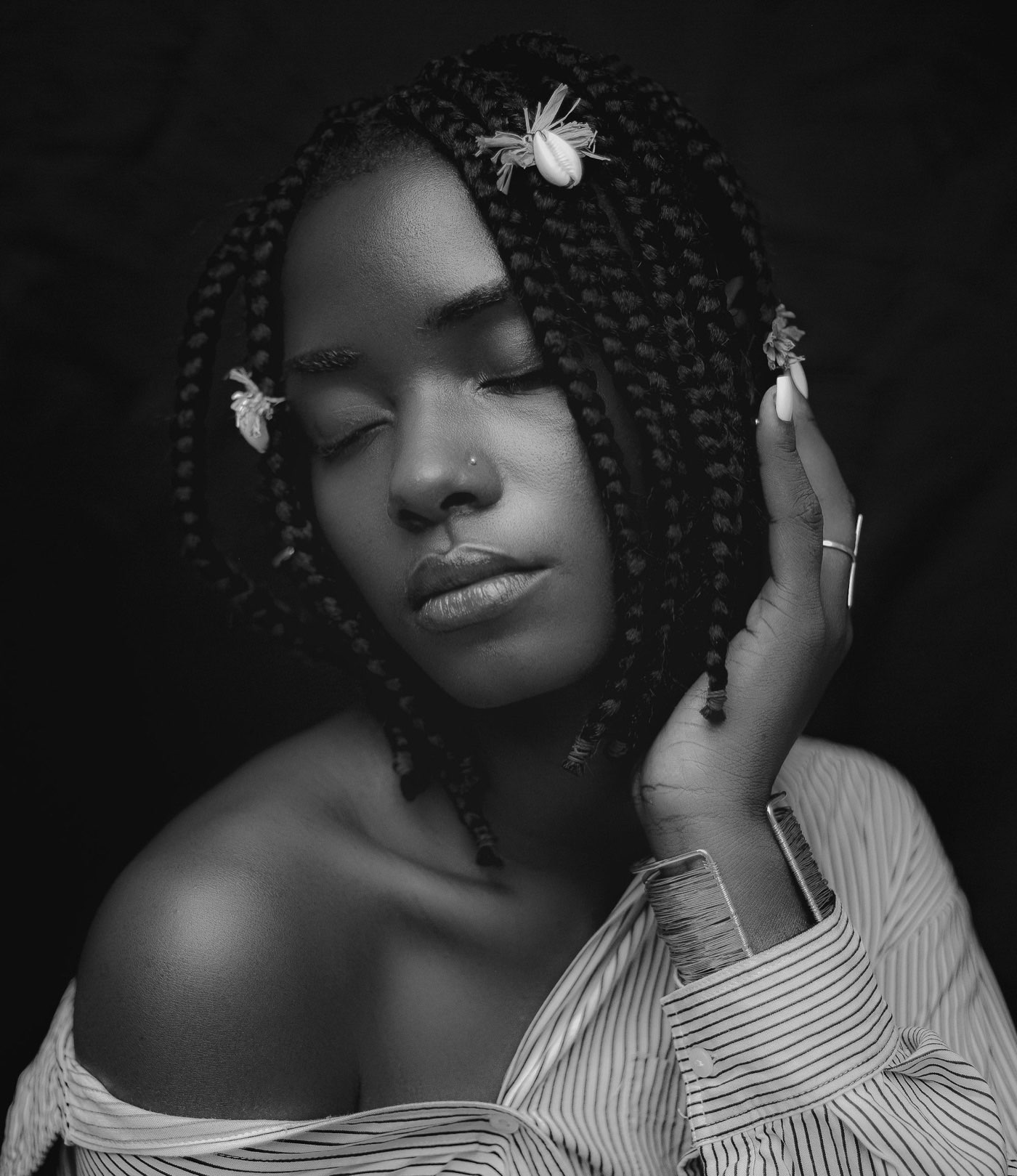 Black and white editorial beauty portrait of a model with braided hair, eyes closed