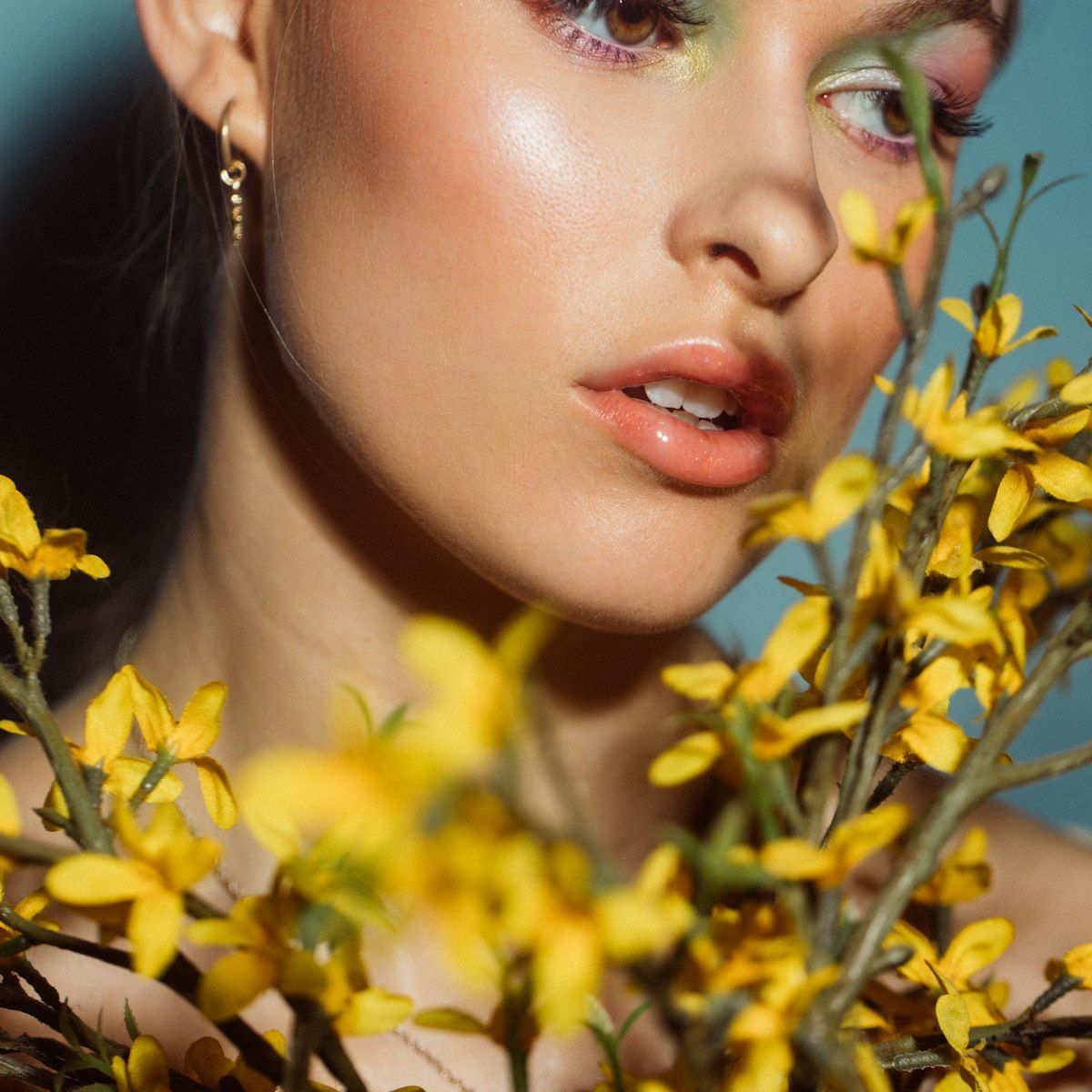 Beauty model posed with bright yellow flowers