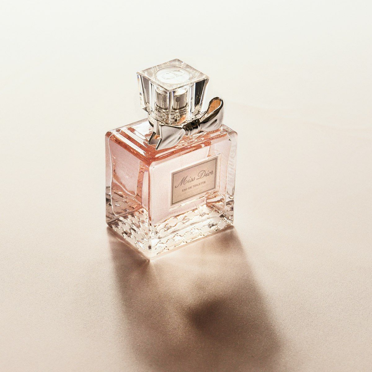 Soft pink-gold perfume bottle in gentle light