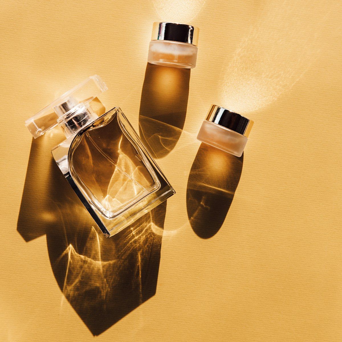 Gold perfume bottles caught mid-spray on gold